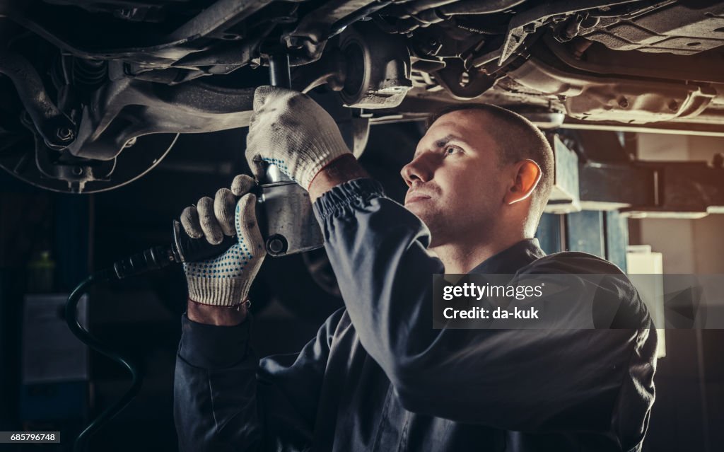 プロのメカニックが自動車修理工場で車を修理