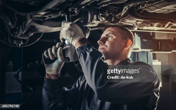 professional mechanic repairing a car in auto repair shop - machine part stock pictures, royalty-free photos & images