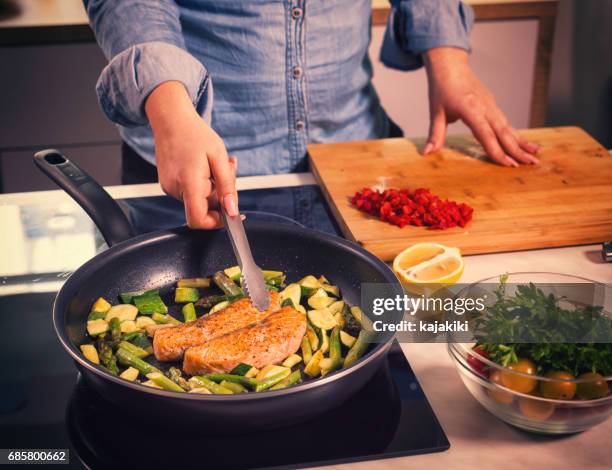 mujeres jóvenes preparar salmón en casa - squash vegetable fotografías e imágenes de stock