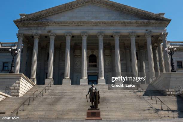 An exterior view of the South Carolina State House, with a statue of George Washington in the foreground - construction work first began in on the...