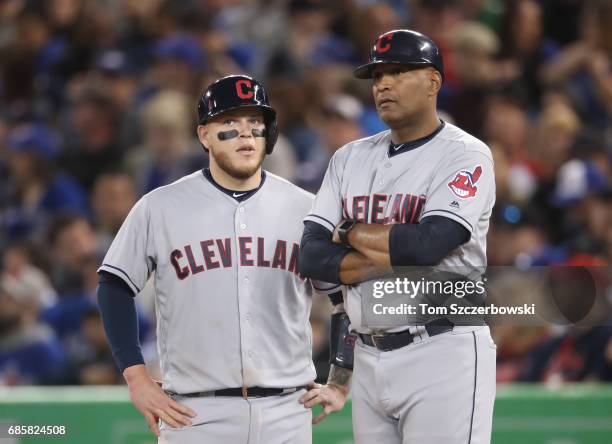 Roberto Perez of the Cleveland Indians talks to first base coach Sandy Alomar Jr. #15 in the eighth inning during MLB game action against the Toronto...