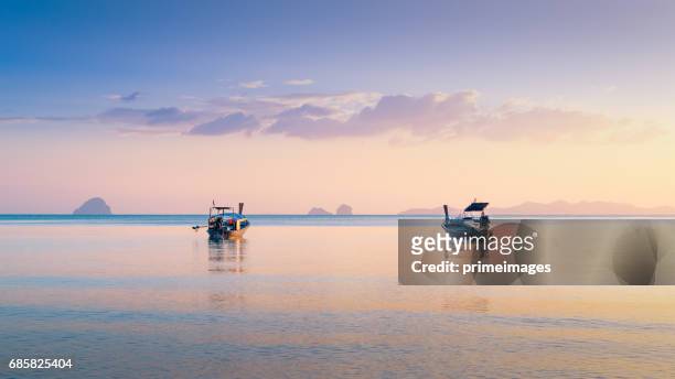 beautiful sunset at tropical sea with long tail boat in south thailand - phuket stock pictures, royalty-free photos & images