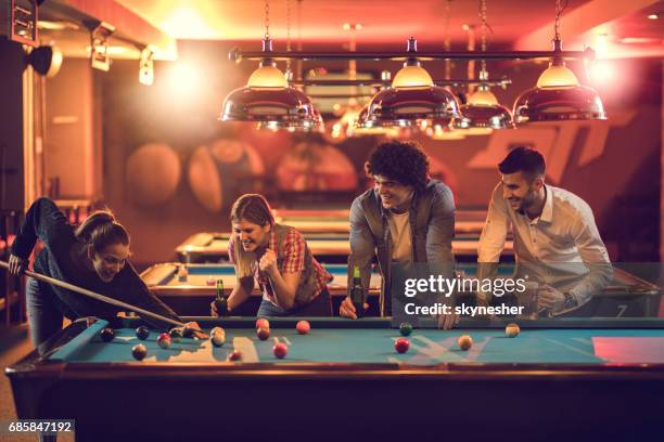 group of happy friends enjoying in billiard game in a pool hall. - pool table stock pictures, royalty-free photos & images