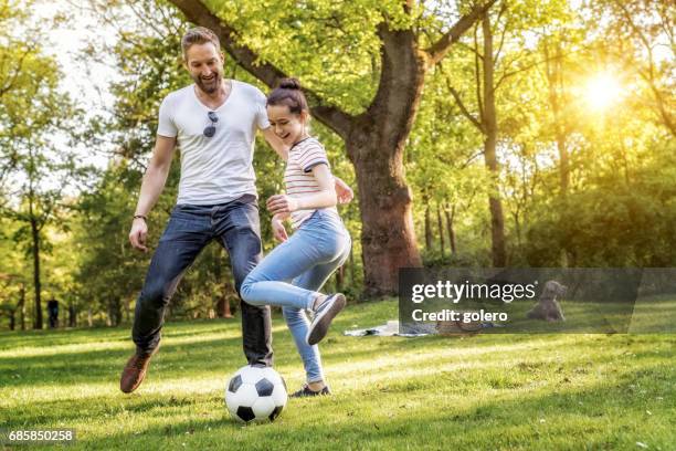 bärtige vater und tochter im teenageralter fußball spielen auf sommerwiese - park relaxing stock-fotos und bilder