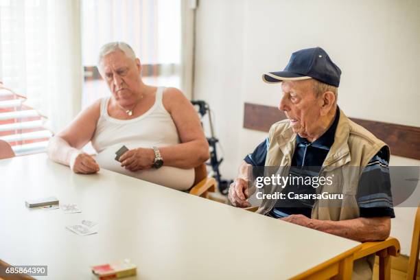 senior men playing card for relaxation in the nursing home - only senior men stock pictures, royalty-free photos & images