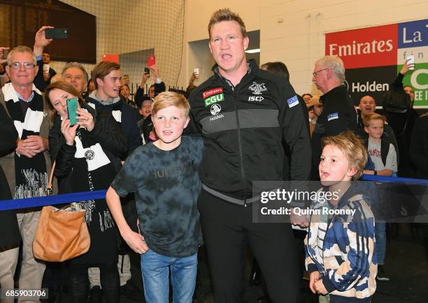 Magpies head coach Nathan Buckley sings the song in the rooms with his sons Jet and Ayce after winning the round nine AFL match between the...