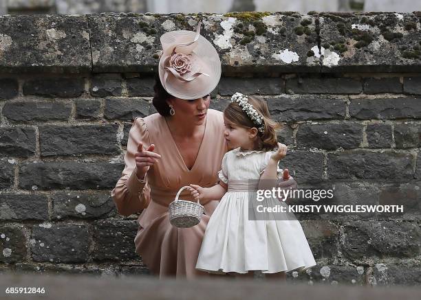 Britain's Catherine, Duchess of Cambridge speaks to her daughter Britain's princess Charlotte, a bridesmaid, following the wedding of her sister...