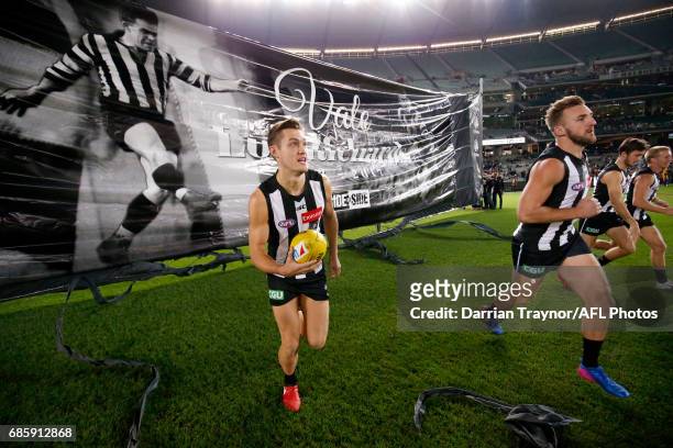 Collingwood players run through the banner before the round nine AFL match between the Collingwood Magpies and the Hawthorn Hawks at Melbourne...
