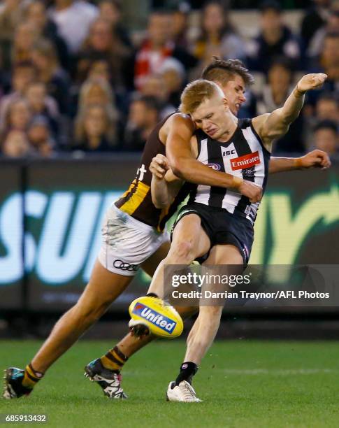 Daniel Howe of the Hawks tackles Adam Treloar of the Magpies during the round nine AFL match between the Collingwood Magpies and the Hawthorn Hawks...