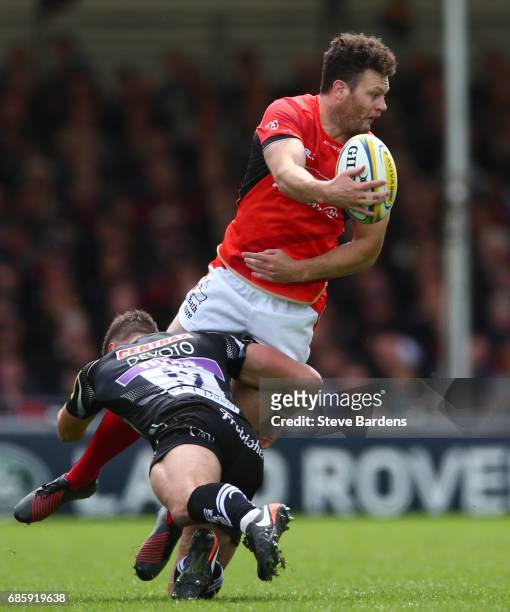 Duncan Taylor of Saracens offloads as he is tackled by Ollie Devoto of Exeter Chiefs during the Aviva Premiership semi final match between Exeter...