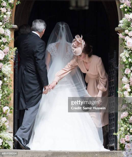 Catherine, Duchess of Cambridge adjusts Pippa's wedding dress as they arrive for the wedding Of Pippa Middleton and James Matthews as a page boy...