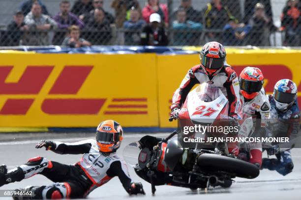 Italy's rider Manuel Pagliani crashes with his Mahindra CIPN°96 ahead of Japan's rider Kaito Toba on his Honda Team Asia N°27 during a Moto3...