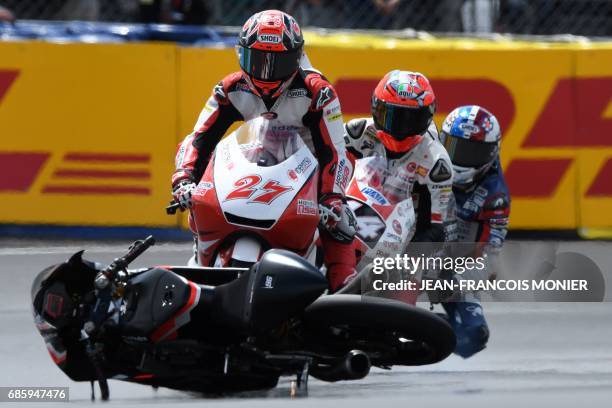 Japan's rider Kaito Toba on his Honda Team Asia N°27 is about to crash with the motorcycle of Italy's rider Manuel Pagliani during a Moto3 qualifying...