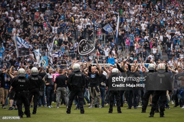 Fans of Hamburg storm the pitch after the Bundesliga match between Hamburger SV and VfL Wolfsburg at Volksparkstadion on May 20, 2017 in Hamburg,...