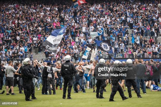 Fans of Hamburg storm the pitch after the Bundesliga match between Hamburger SV and VfL Wolfsburg at Volksparkstadion on May 20, 2017 in Hamburg,...