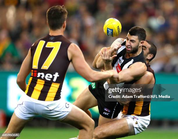 Alex Fasolo of the Magpies is tackled by Shaun Burgoyne of the Hawks during the 2017 AFL round 09 match between the Collingwood Magpies and the...