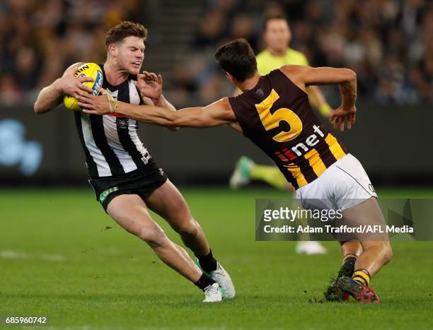 Taylor Adams of the Magpies is tackled by Ryan Burton of the Hawks during the 2017 AFL round 09 match between the Collingwood Magpies and the...