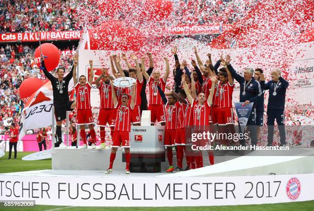 Philipp Lahm of Bayern Muenchen lifts the Championship trophy in celebration of the 67th German Championship title following the Bundesliga match...
