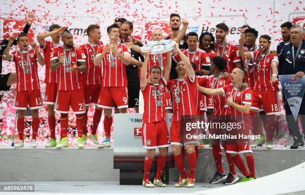 Philipp Lahm and Xabi Alonso of Bayern Muenchen lift the Championship trophy in celebration of the 67th German Championship title following the...