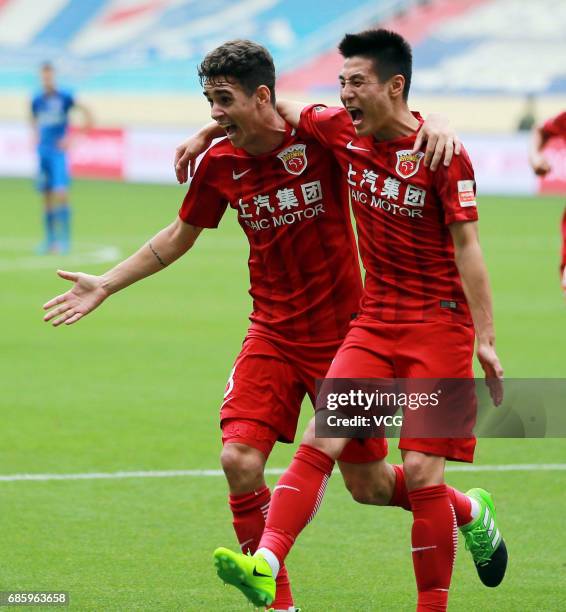 Oscar of Shanghai SIPG celebrates with team mate Wu Lei after scoring a goal during the 10th round match of CSL Chinese Football Association between...