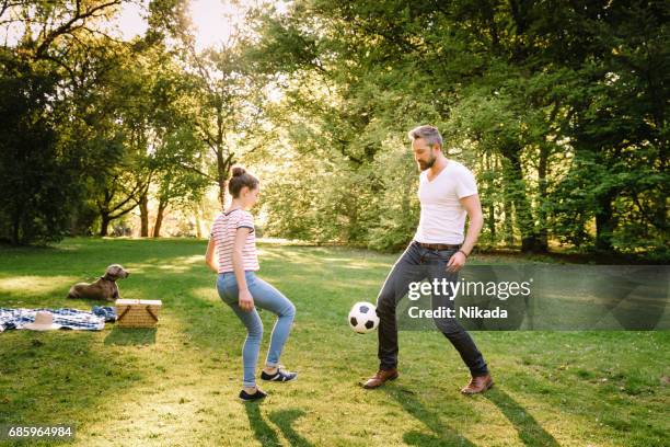 father and teenage daughter playing soccer in park - father and daughter play imagens e fotografias de stock