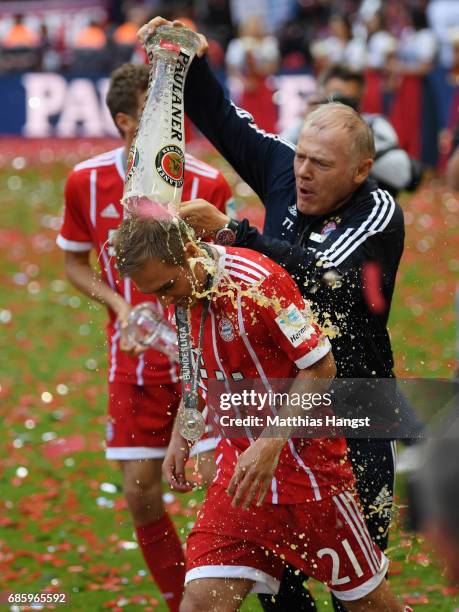 Philipp Lahm of Bayern Muenchen receives a beer shower from Bayern assistant coach Hermann Gerland following the Bundesliga match between Bayern...