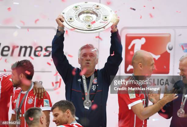 Carlo Ancelotti, Manager of Bayern Muenchen poses with the Championship trophy in celebration of the 67th German Championship title following the...