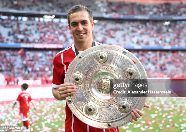 Philipp Lahm of Bayern Muenchen poses with the Championship trophy in celebration of the 67th German Championship title following the Bundesliga...