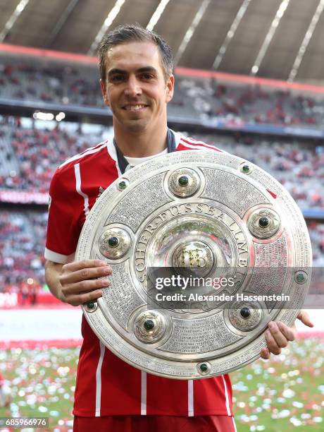 Philipp Lahm of Bayern Muenchen poses with the Championship trophy in celebration of the 67th German Championship title following the Bundesliga...