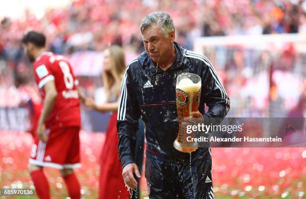 Carlo Ancelotti, Manager of Bayern Muenchen is showered in beer by his players following the Bundesliga match between Bayern Muenchen and SC Freiburg...