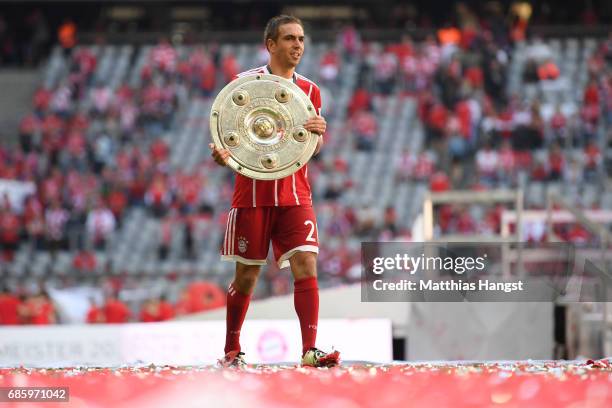 Philipp Lahm of Bayern Muenchen poses with the Championship trophy in celebration of the 67th German Championship title following the Bundesliga...