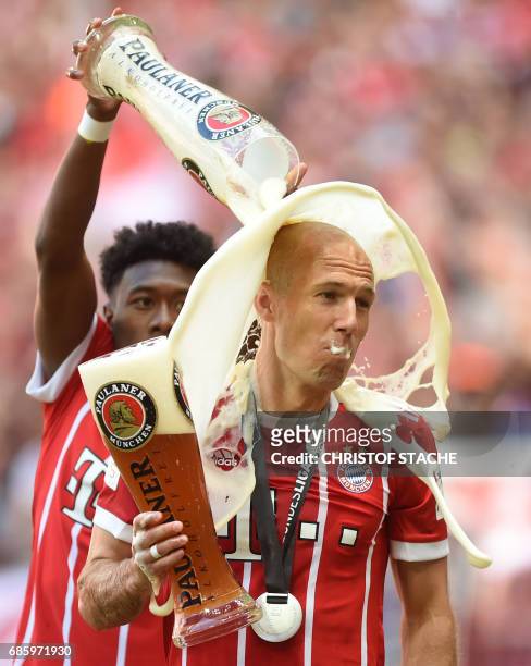 Bayern Munich's Austrian defender David Alaba pours beer over Bayern Munich's Dutch midfielder Arjen Robben after the German first division...