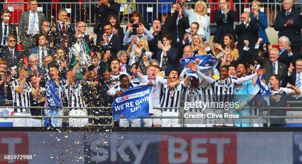 Captain Tony Craig of Millwall lifts the trophy as he celebrates victory and promotion with team mates after the Sky Bet League One Playoff Final...