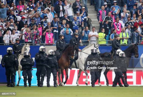 Police with horses is seen on the pitch after the Bundesliga match between Hamburger SV and VfL Wolfsburg at Volksparkstadion on May 20, 2017 in...