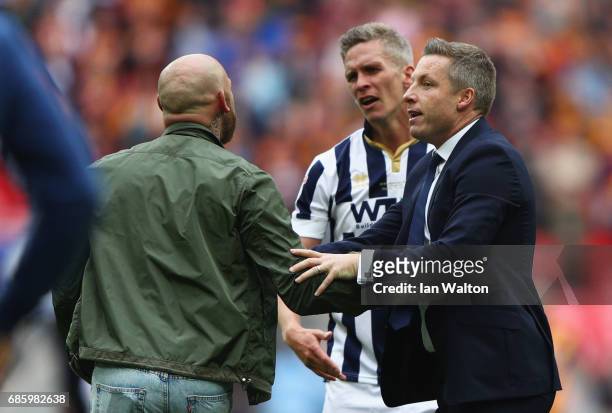 Winning goalscorer Steve Morison of Millwall and Neil Harris manager of Millwall instruct invading Millwall fans to leave the pitch after victory in...