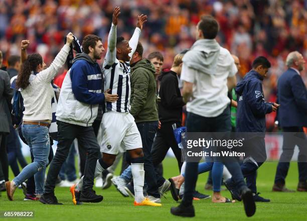 Fred Onyedinma of Millwall is mobbed by Millwall fans as they invade the pitch in celebration after the Sky Bet League One Playoff Final between...