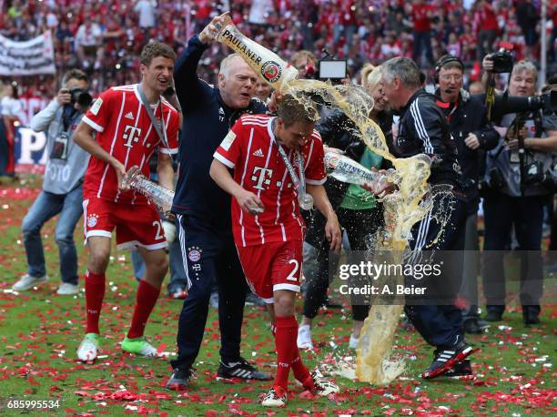 Philipp Lahm of Bayern Muenchen receives a beer shower from Bayern assistant coach Hermann Gerland following the Bundesliga match between Bayern...