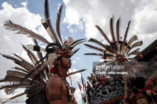 Dayak tribe members wear traditional clothing adorned with animal skull necklaces as they take part in an annual festival in Pontianak, West...