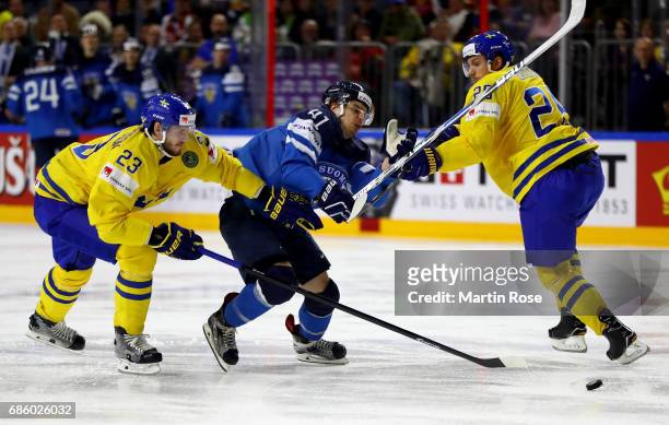 Oliver Ekman Larsson and Jonas Brodin of Sweden challenge Antti Pihlstrom of Finland for the puck during the 2017 IIHF Ice Hockey World Championship...