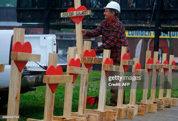 Greg Zanis unloads wooden crosses from the back of his truck at a planned prayer vigil and rally against violence in Chicago, Illinois on May 20,...