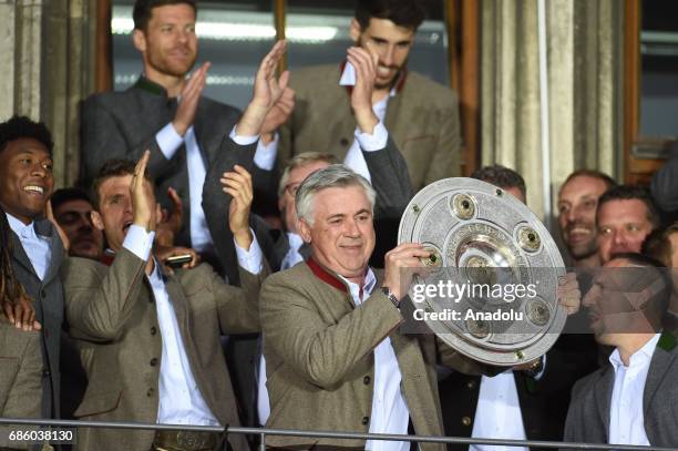 Head Coach Carlo Ancelotti of Bayern Munich celebrates winning the German soccer championship with the trophy on a balcony of the town hall in...