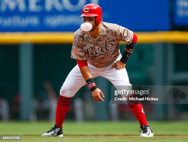 Eugenio Suarez of the Cincinnati Reds leads off at first base while blowing a bubble during the second inning against the Colorado Rockies at Great...