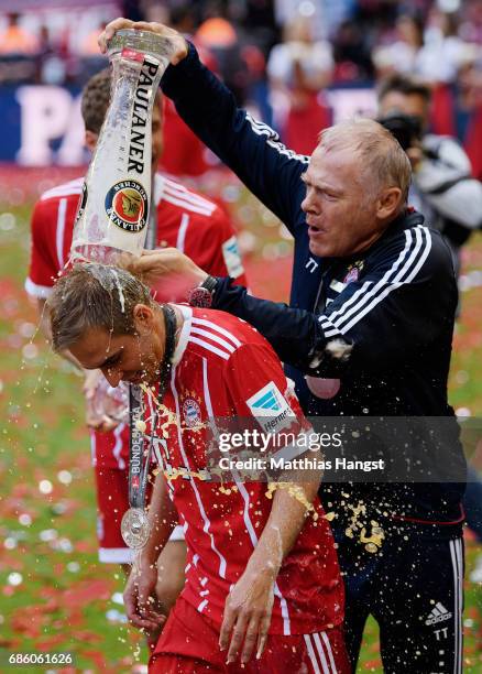 Philipp Lahm of Bayern Muenchen receives a beer shower from Bayern assistant coach Hermann Gerland following the Bundesliga match between Bayern...