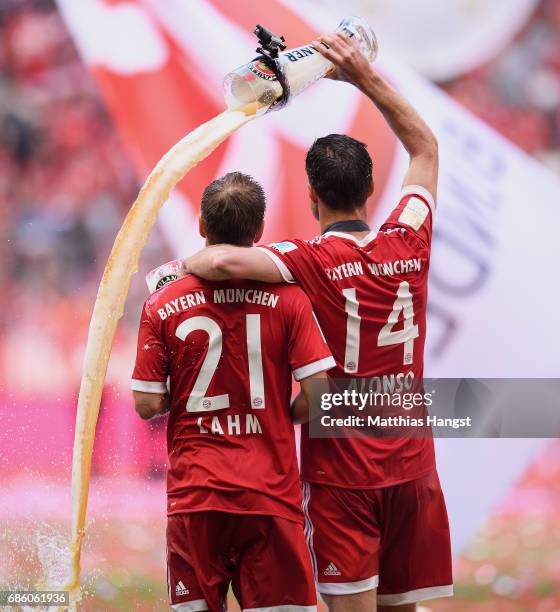 Philipp Lahm and Xabi Alonso of Bayern Muenchen celebrate following the Bundesliga match between Bayern Muenchen and SC Freiburg at Allianz Arena on...