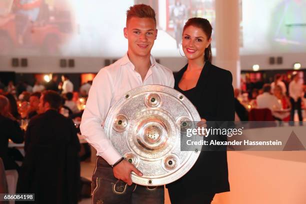 Joshua Kimmich and his partner Lina Meyer pose with the trophy during the FC Bayern Muenchen Championship party following the Bundesliga match...