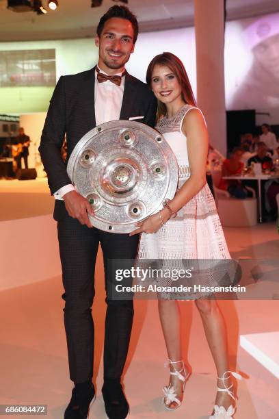 Mats Hummels and his wife Cathy Hummels pose with the trophy during the FC Bayern Muenchen Championship party following the Bundesliga match between...