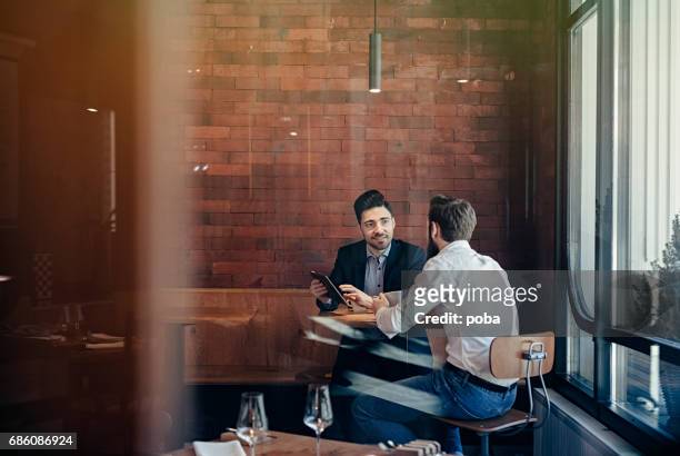 two businessmen talking in restaurant - cafe meeting stock pictures, royalty-free photos & images