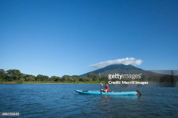 kayaker on  lake nicaragua and the concepcion volcano. - nicaragua fotografías e imágenes de stock