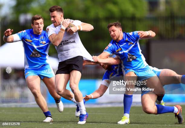 Blake Wallace of Toronto Wolfpack is tackled by James Duerden, Lewis Charnock and Joe Bullock of Barrow Raiders in the first half of a Kingstone...