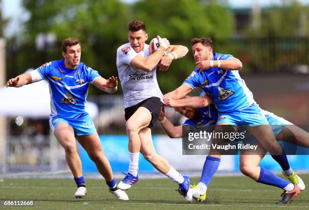 Blake Wallace of Toronto Wolfpack is tackled by James Duerden, Lewis Charnock and Joe Bullock of Barrow Raiders in the first half of a Kingstone...